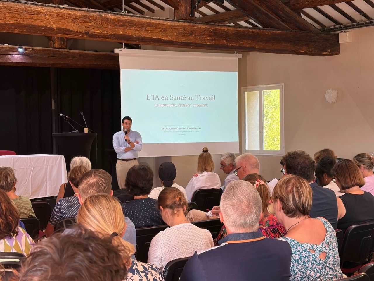 Charles Broutin presenting AI in occupational health to society members gathered in Montpellier
